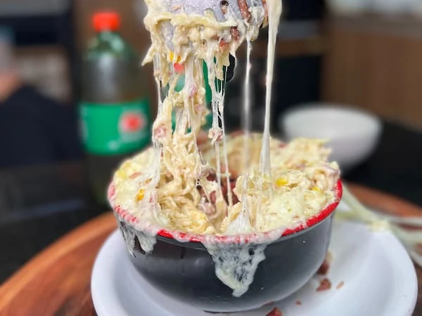 Macarrão cremoso da Na Chapa com bacon, calabresa, milho e queijo
