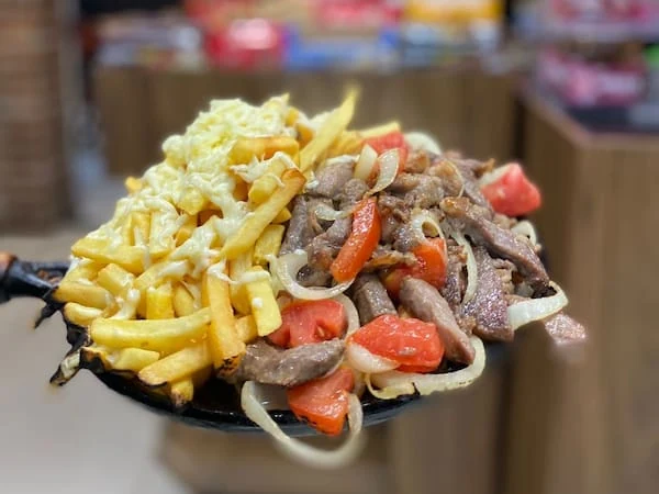 Torre Eiffel, porção de contra-filé com fritas, queijo, cebola e tomate